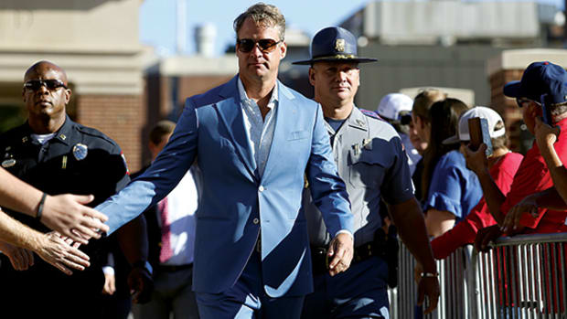 Lane Kiffin offers a low five to fans.